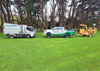 An image of Elite Arboriculture white trucks while the other has a connected arbor grinding equipment